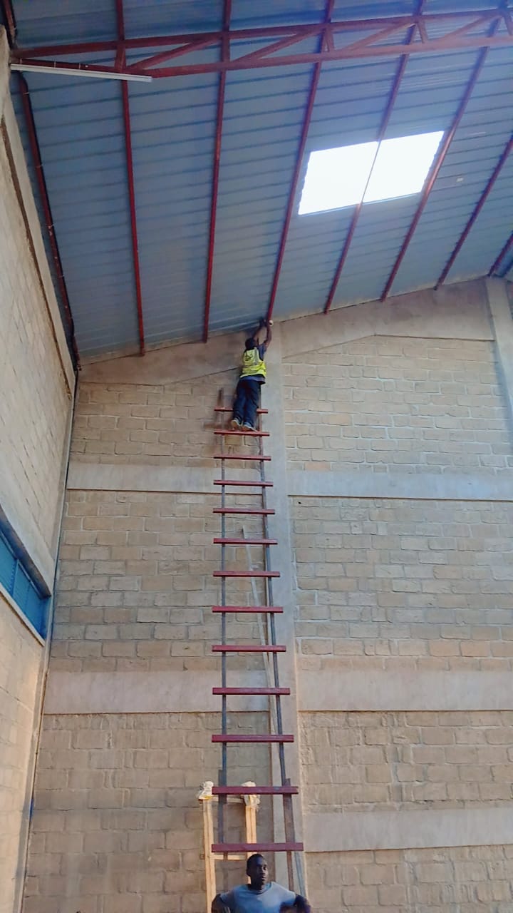 Technicians routing network cable in industrial space